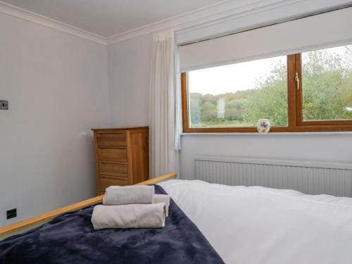 a bedroom with a large bed and a window at Ravenglass Retreat in Ravenglass