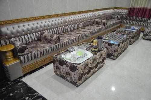a row of couches in a living room with a table at Five Continents Hotel in Sur