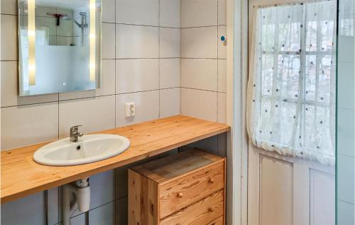 3 Bedroom Nice Home In Hyggen في Hyggen: حمام مع حوض ومرآة