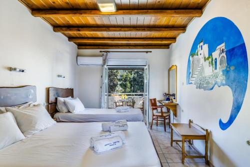 a hotel room with two beds and a table at Ionia Hotel in Skopelos Town