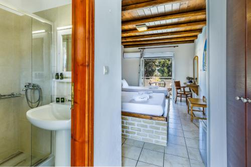 a bathroom with a sink and a bed in a room at Ionia Hotel in Skopelos Town