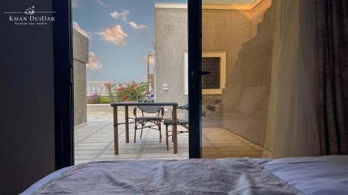 a bedroom with a view of a patio with a table at Khan Duidar Inn - Pyramids View Rooftop in Cairo
