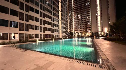 a swimming pool in front of a building at night at Klia Horizon Suite Kota Warisan in Sepang