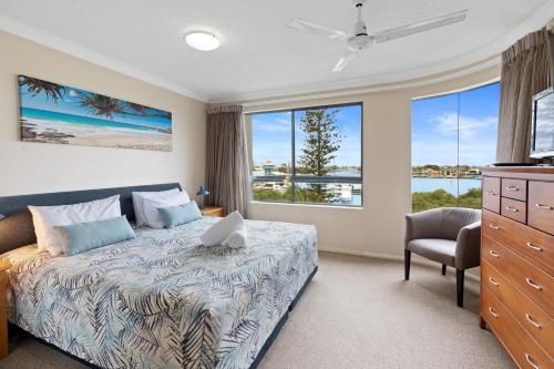 a bedroom with a bed and a large window at Riverdance Apartments in Mooloolaba