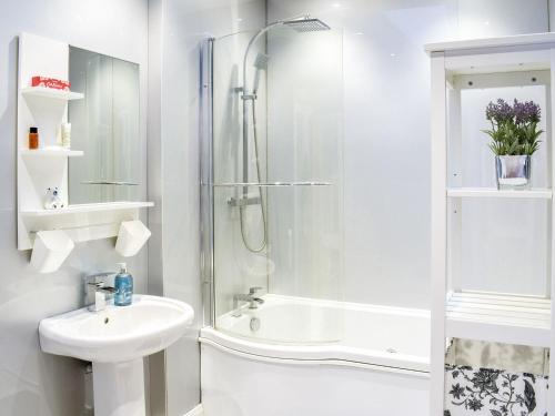 a white bathroom with a shower and a sink at Dairy Cottage - Uk39522 in Maybole