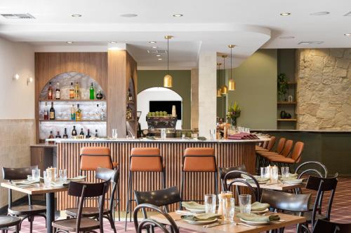 a restaurant with tables and chairs and a bar at Mantra Mount Gambier in Mount Gambier