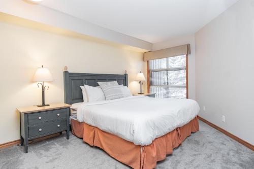 a bedroom with a large bed and a window at The best ski in ski out two bedroom condo at Aspens in Whistler