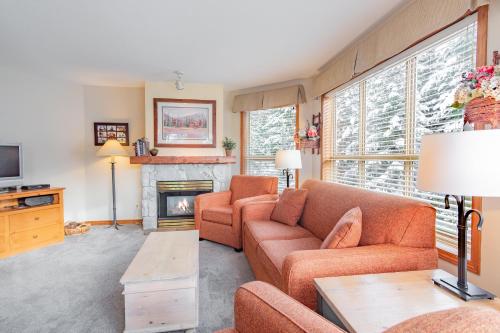 a living room with a couch and a fireplace at The best ski in ski out two bedroom condo at Aspens in Whistler