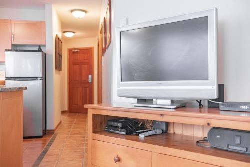 a flat screen tv sitting on top of a wooden entertainment center at The best ski in ski out two bedroom condo at Aspens in Whistler