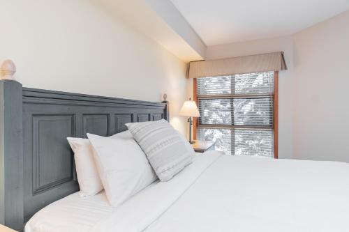 a bedroom with a large white bed with white pillows at The best ski in ski out two bedroom condo at Aspens in Whistler