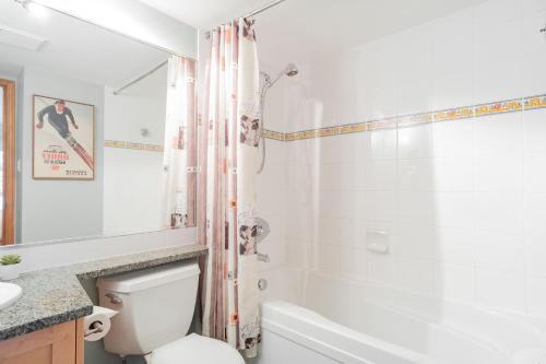 a white bathroom with a toilet and a shower at The best ski in ski out two bedroom condo at Aspens in Whistler