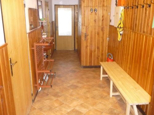 a hallway with a wooden bench and a door at Chalupa u Vyšanských in Jilemnice