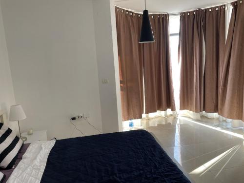 a bedroom with a bed and a large window at Gorgeous duplex in heart of Jerusalem in Jerusalem