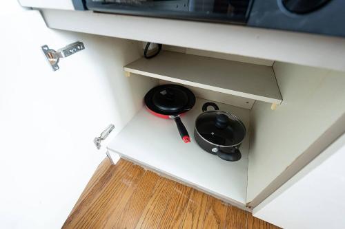 a black frying pan in a drawer in a microwave at HONGO 11 HOTEL in Tsukisappu