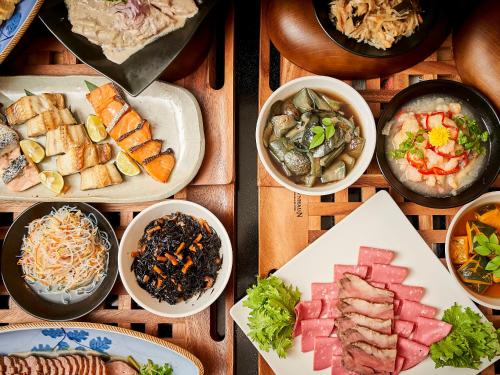 a table with plates of food and bowls of food at Hotel Viamare Kobe in Kobe