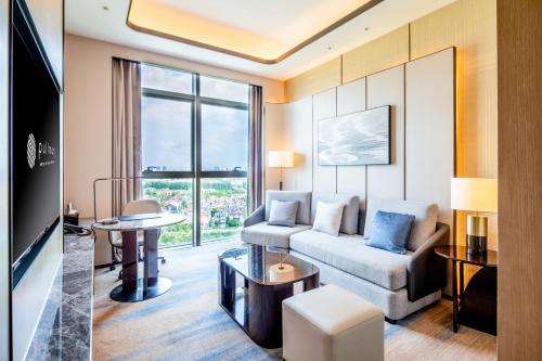 a living room with a couch and a table at Pullman Suzhou Taicang in Taicang