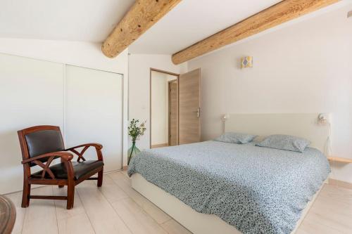 a white bedroom with a bed and a chair at Gîte La Quille - Maison de hameau en Provence pour 4 personnes avec jardin privatif in Le Puy-Sainte-Réparade