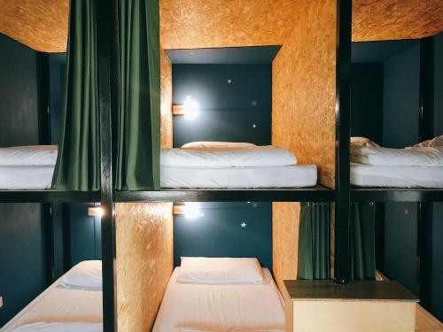 a room with three bunk beds and a mirror at South Talk B&B in Hengchun South Gate