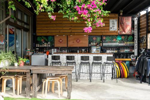 a bar with stools and a table and chairs at South Talk B&B in Hengchun