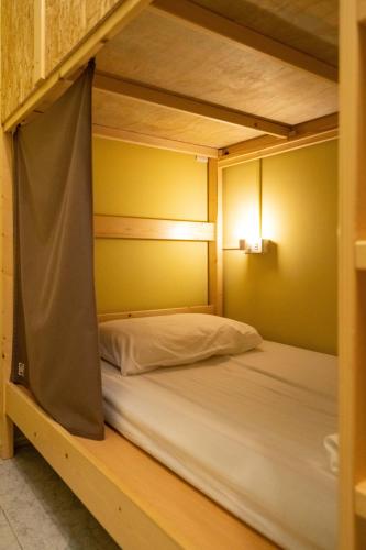 an empty bunk bed in a room with yellow walls at South Talk B&B in Hengchun
