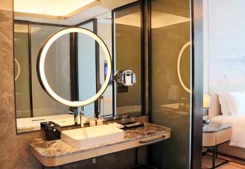 a bathroom with a sink and a mirror at Pullman Suzhou Taicang in Taicang