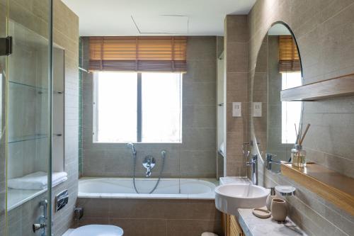 een badkamer met een bad, een toilet en een wastafel bij Dubai Marina, Two bedrooms apartment with full Marina View in Dubai