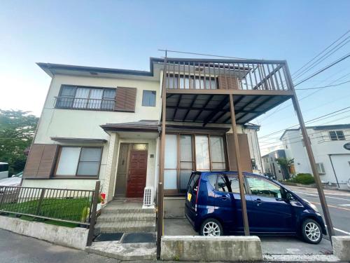 a small blue car parked in front of a house at 富士旅の家 in Fujikawaguchiko