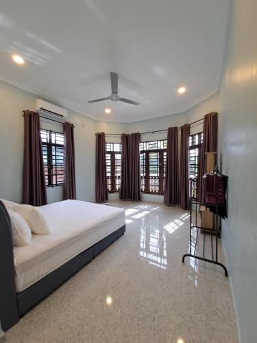 a bedroom with a bed and some windows at ZN Homestay Gong Badak in Kampong Pengkalan Maras