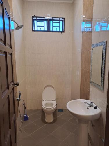 a bathroom with a toilet and a sink and a window at ZN Homestay Gong Badak in Kampong Pengkalan Maras