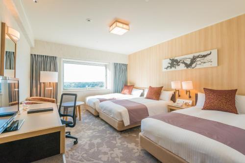 a hotel room with two beds and a television at Hotel Nikko Narita in Narita