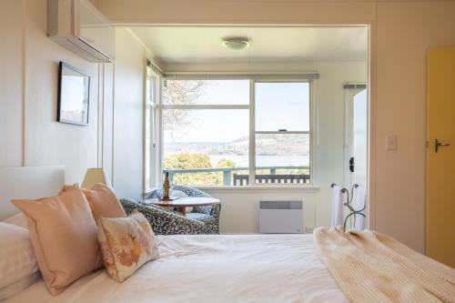 een slaapkamer met een bed en een groot raam bij Olive's Cottage in Windermere
