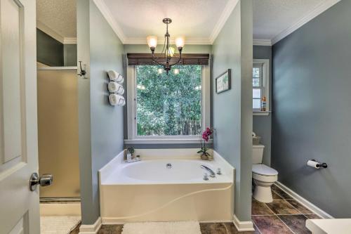 a bathroom with a bath tub and a window at Peaceful Dallas Home with Deck and Charcoal Grill in Hiram