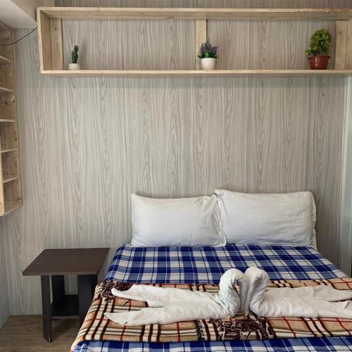 1 dormitorio con 1 cama con 2 toallas en Tagaytay Prime Residences with FREE wifi netflix light cooking viewdeck, en Tagaytay