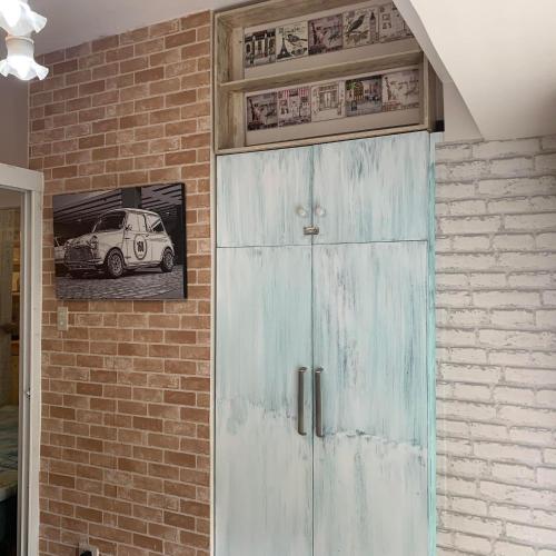 eine blaue Tür in einer Ziegelmauer mit einem Bild eines Autos in der Unterkunft Tagaytay Prime Residences with FREE wifi netflix light cooking viewdeck in Tagaytay
