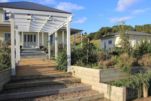 a porch of a house with a white pergola at Tracy's Boutique B&B Farmstay in Wellsford