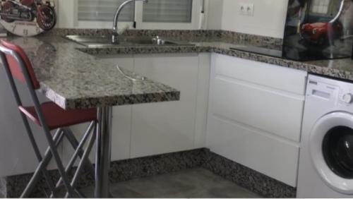 eine Küche mit einer Spüle und einer Waschmaschine in der Unterkunft VillavistasB in Hornachuelos