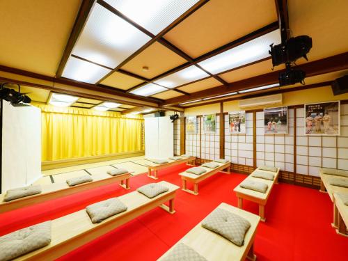uma sala com uma fila de bancos e mesas em Ureshino Onsen Kotobukiya em Ureshino