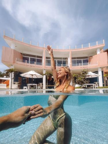 a woman sitting on the edge of a swimming pool at Belika Beach in Hiriketiya