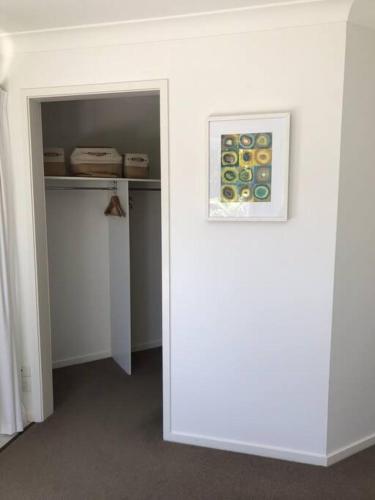 a white room with a painting on the wall at Beachfront Retreat - Ducted Air - Free Wifi in Coffs Harbour