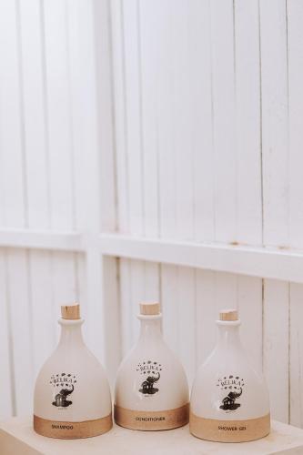 three white vases sitting on a shelf at Belika Beach in Hiriketiya