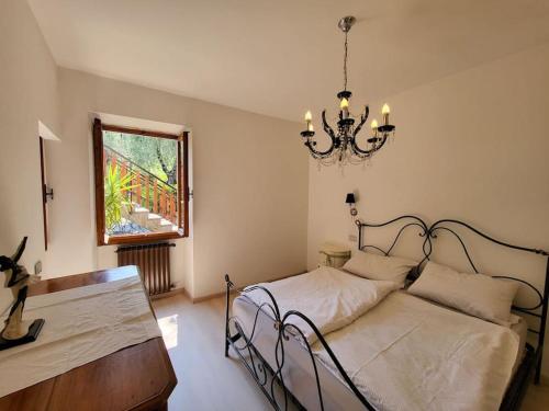 una camera con letto e lampadario a braccio di Villa Olivo a Limone sul Garda