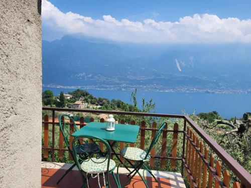 a table and chairs on a balcony with a view of the water at Villa Olivo in Limone sul Garda