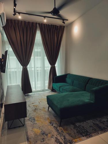 sala de estar con sofá verde y mesa en Amar & Nora Homestay en Ipoh