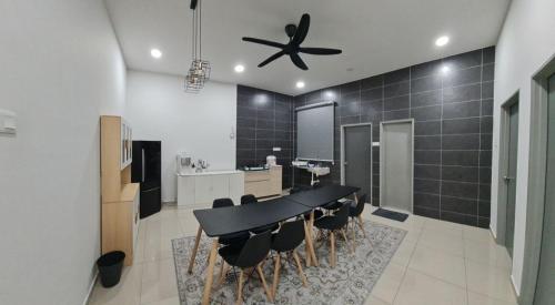a dining room with a black table and chairs at AYA HOMESTAY BANDAR MELAKA in Melaka