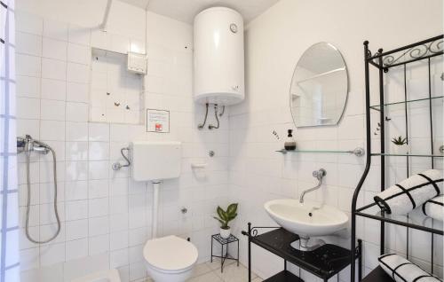 Baño blanco con lavabo y aseo en Nice Home In Poljica With House Sea View en Marina