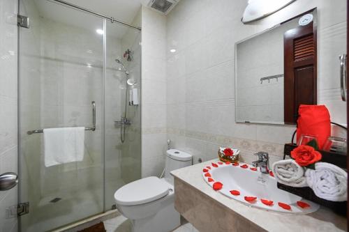 y baño con aseo, lavabo y ducha. en Quang Hoa Airport Hotel en Ho Chi Minh