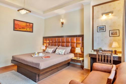 a bedroom with a bed and a desk and a chair at StayVista at Stonehill Manor with Outdoor Sitting in Dharamshala
