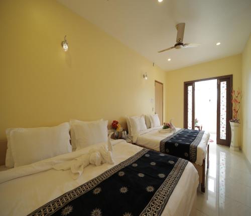 Una habitación de hotel con dos camas con gatos. en Nadanam Inn en Pondicherry