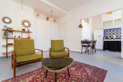 un salon avec deux chaises et une table dans l'établissement Appartement le Fighiéra, à Nice