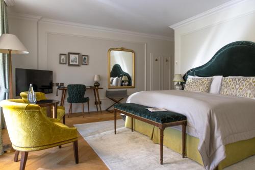 a bedroom with a large bed and a table and chairs at Victoria Jungfrau Grand Hotel & Spa in Interlaken